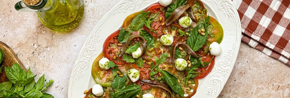Carpaccio de tomàquet amb mozzarella, anxoves i vinagreta de pesto: una recepta ideal pels dies d’estiu